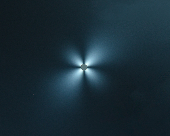 Durch ein Loch scheint weißes Licht, welches sich in 4 Richtungen entfaltet, der Hintergrund ist schwarz
