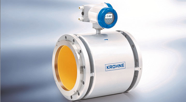 Large industrial flow meter with white-yellow cylindrical housing and digital display